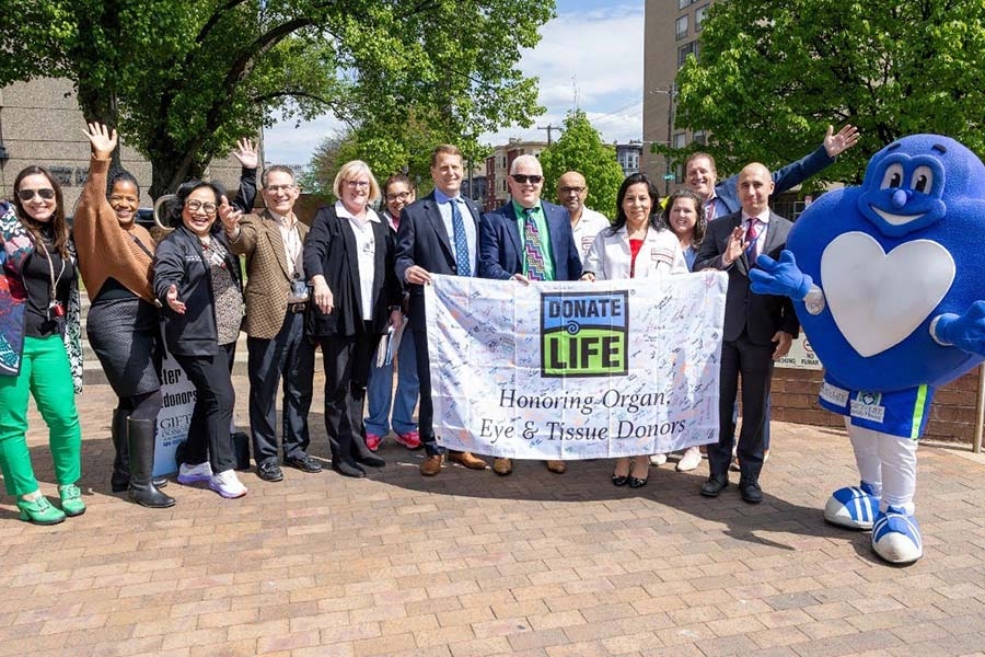 Temple Health team posing with Gift of Life banner and mascot