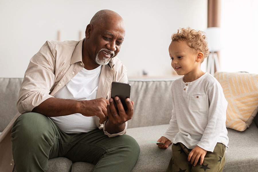 Grandfather showing grandson pictures on his phone