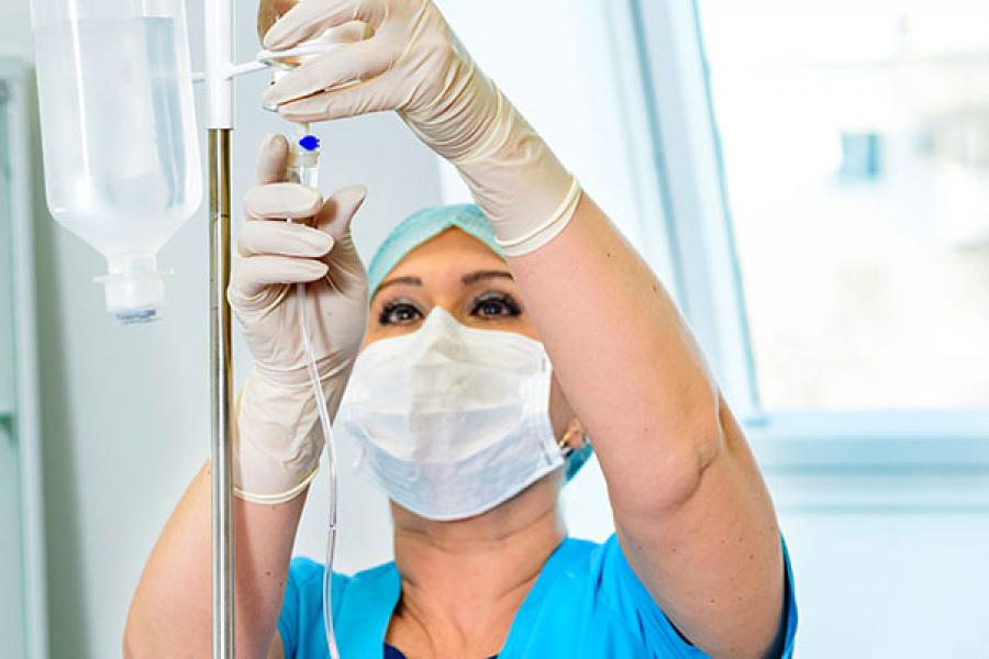 Nurse setting up drip system for patient